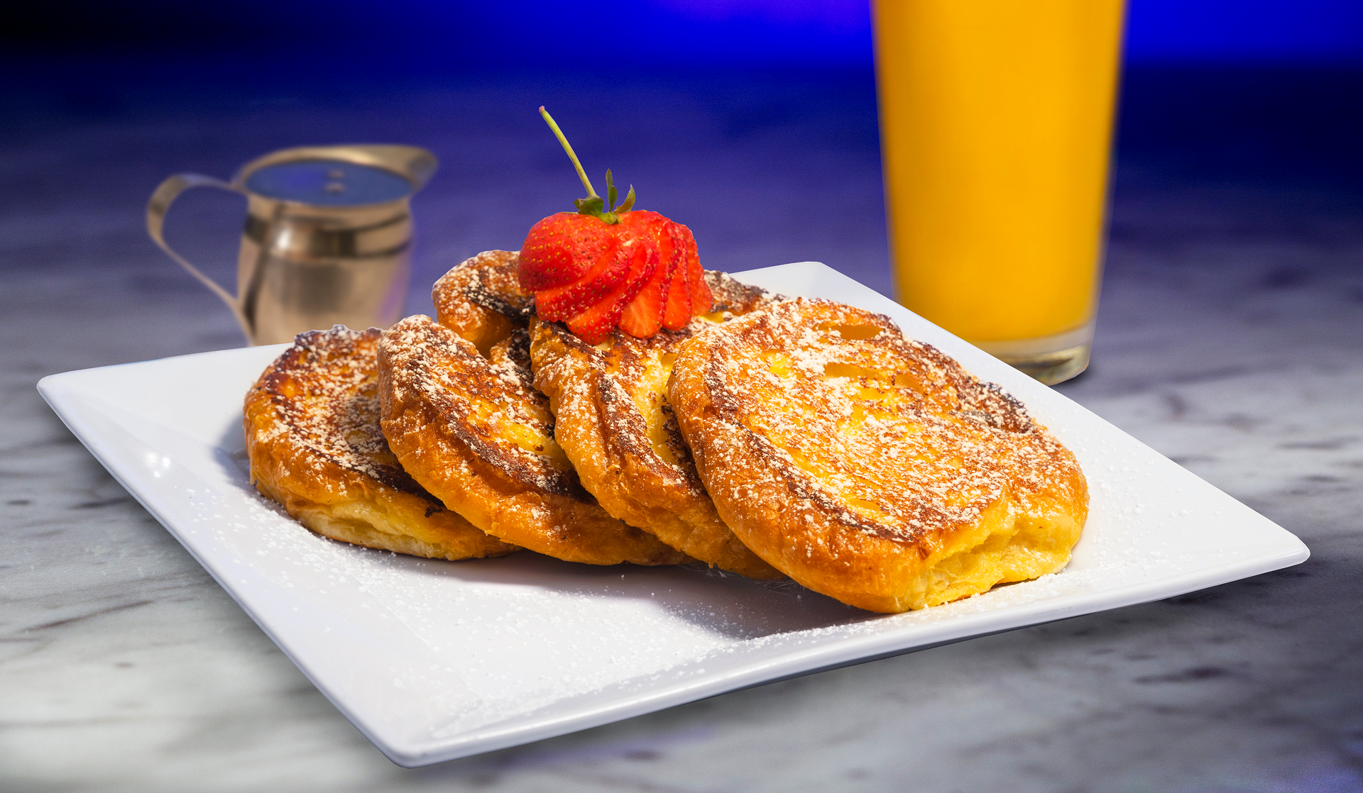 Croissant French Toast with powdered sugar and a strawberry